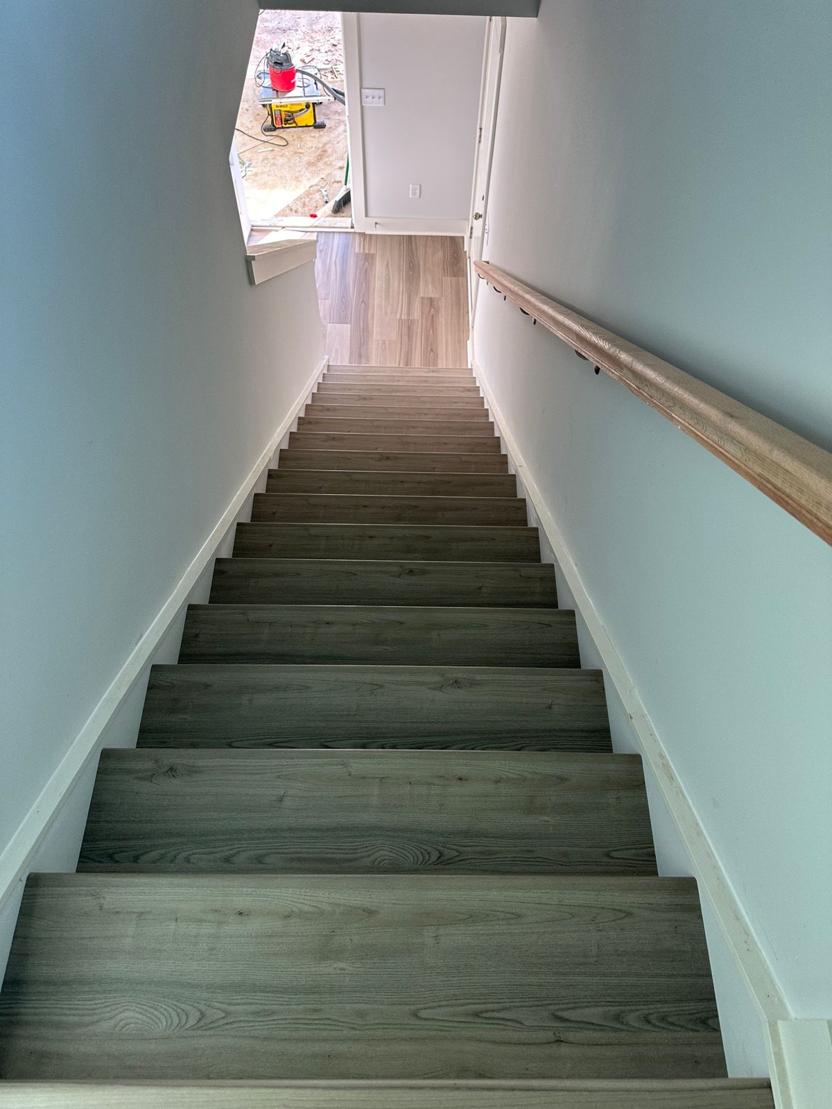 Gray plank staircase looking down toward entry