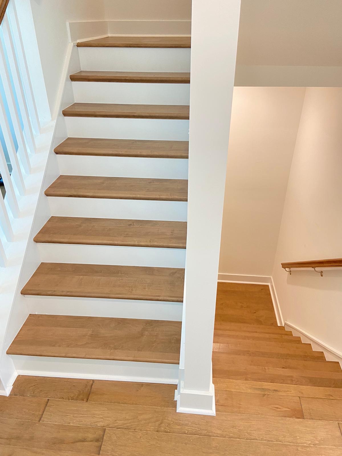 Light oak staircase meeting matching hardwood landing
